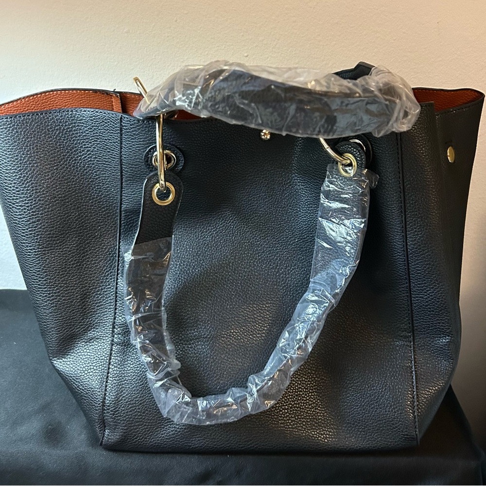 New, large black tote bag, with brown lining. Faux leather.